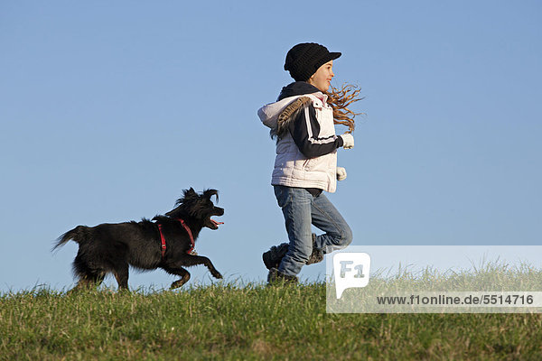 Mädchen läuft mit Hund