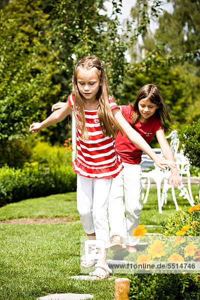 Zwei Mädchen spielen im Garten