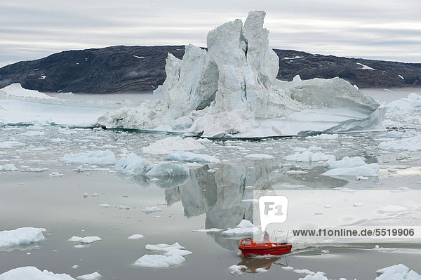 Inuit steuert rotes Motorboot  Eisberge und Eis  Johan Petersen Fjord  Ostgrönland  Grönland
