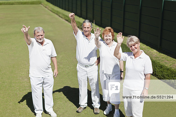 Older people waving from lawn
