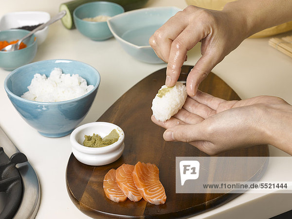 Woman preparing sushi at table