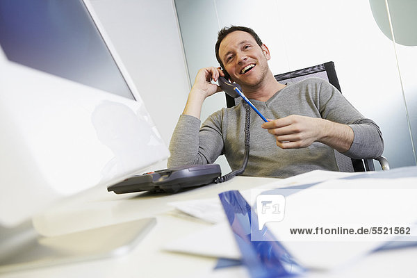 Businessman talking on phone at work