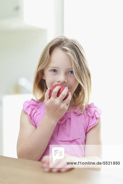 Mädchen essen Apfel in der Küche