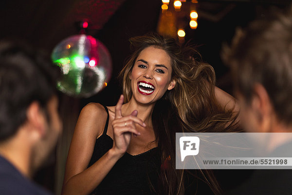 Lächelnde Frau tanzt im Club