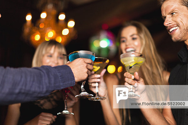 Lächelnde Menschen beim Cocktail im Club