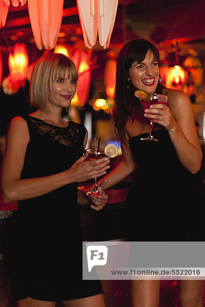 Smiling women having cocktails in bar