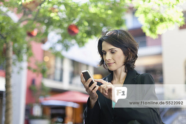 Geschäftsfrau mit Handy im Freien