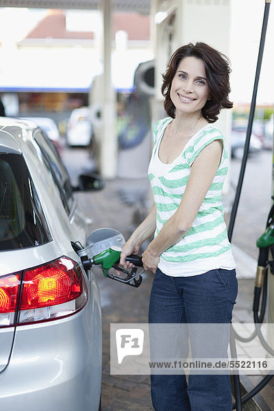 Frau pumpt Gas ins Auto