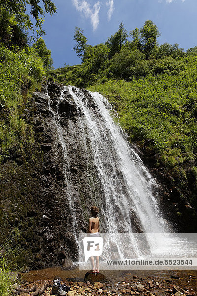 Junger Mann am Wasserfall  Fontaine Salee Reservat  Regional-Naturpark der Vulkane der Auvergne  Sancy-Massiv  Puy de Dome  Frankreich  Europa