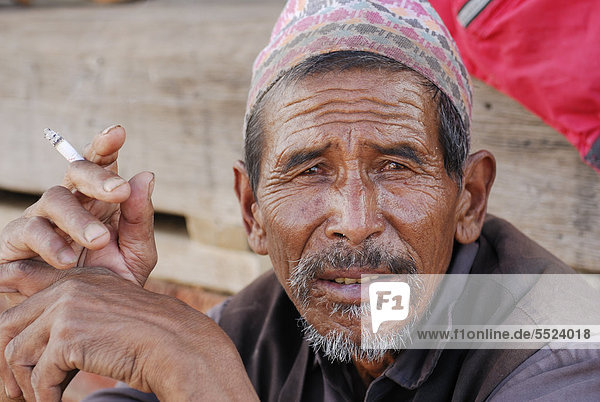 Man with a hat holding a cigarette  portrait  Bhaktapur  Kathmandu Valley  Nepal  Asia