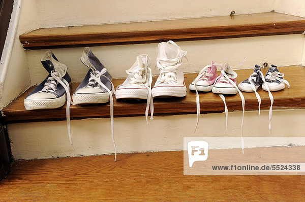 Sport shoes of a family with two children  lined up on a stair