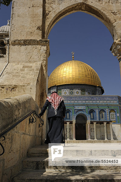 Old Palestinian man wearing a keffiyeh  kufiya mounting the steps to the Dome of the Rock  on Temple Mount  Muslim Quarter  Old City  Jerusalem  Israel  Middle East