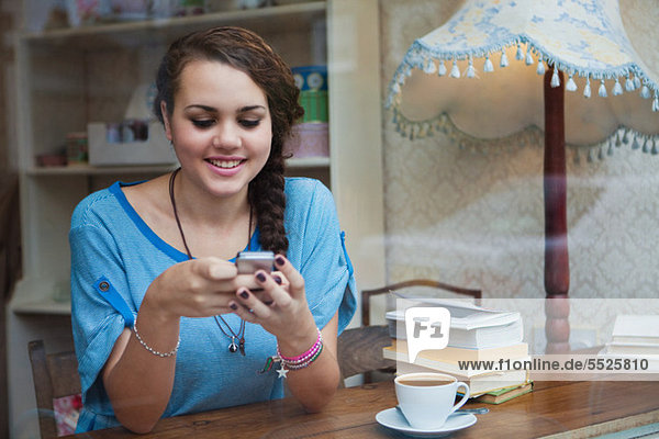 Junge Frau im Cafe mit Handy