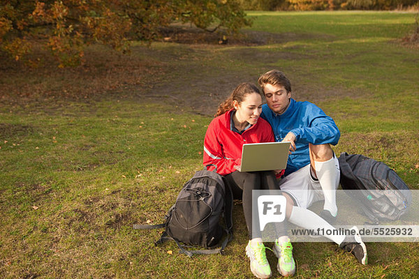 Junges Paar mit Laptop im park