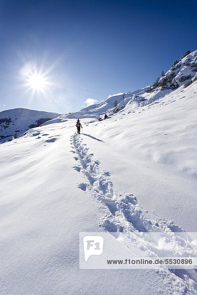 Snowshoer ascending to Jagelealm alpine pasture in Ridnauntal Valley above Entholz  Alto Adige  Italy  Europe