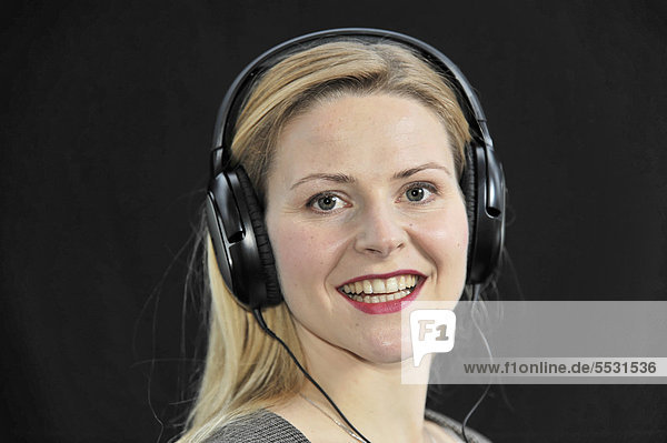 Junge Frau hört mit Kopfhörer Musik