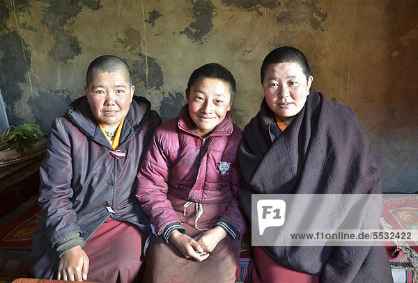 Drei tibetische Nonnen sitzen in der Klosterküche des Nonnenklosters in den Bergen von Kloster Reting  Mount Gangi Rarwa  Himalaya  Lhundrup County  Zentraltibet  Tibet  China