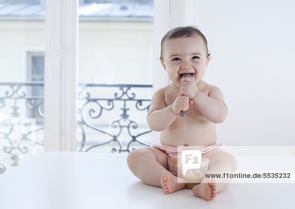 Infant eating with spoon  portrait