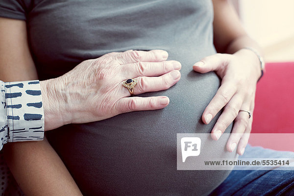Hände auf dem Bauch der Schwangeren