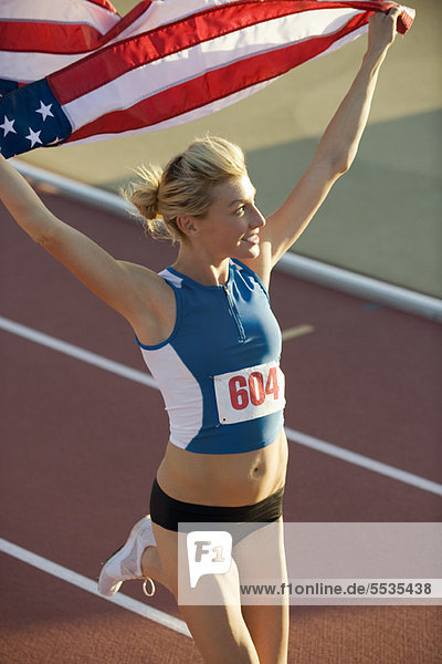Woman running on track with American flag