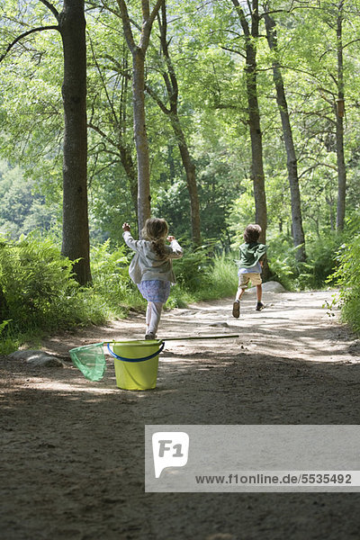 Children running on path through woods