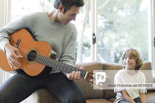 Vater spielt Gitarre für Sohn