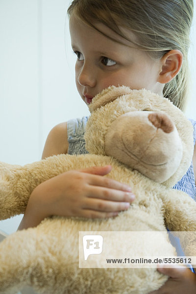 Kleines Mädchen umarmt Teddybär