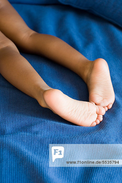 Nackte Beine und Füße des Kindes