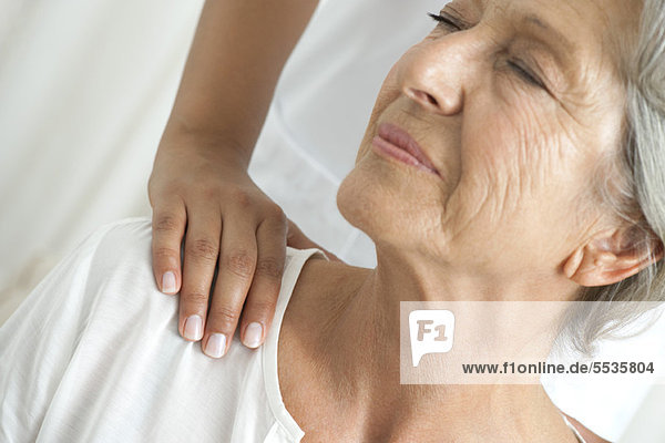 Senior woman getting a shoulder massage  cropped