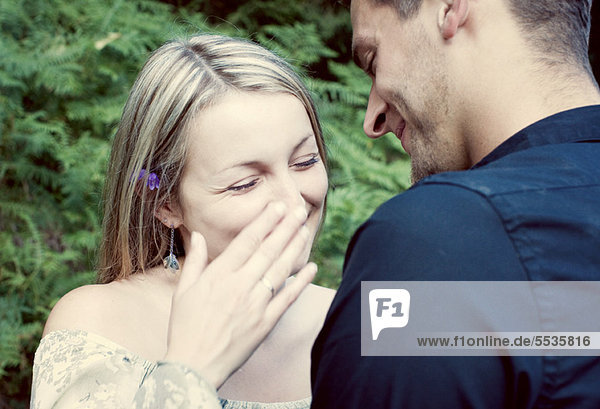 Paar im Freien  Frau lacht und bedeckt ihren Mund