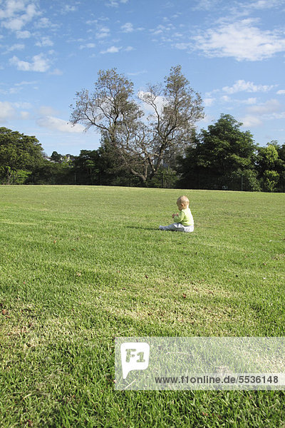 Baby allein im Feld sitzend