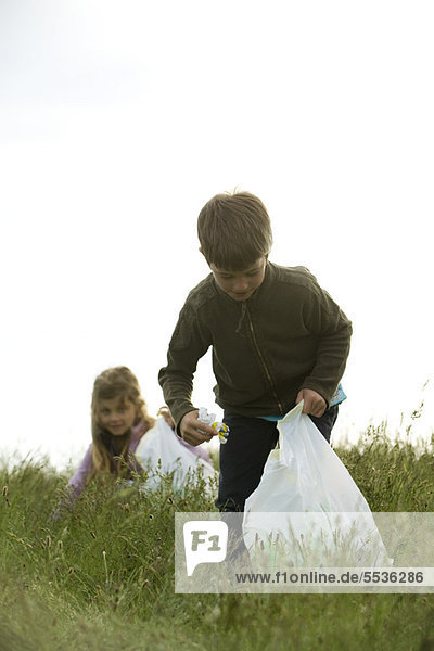 Kinder  die Müll auf dem Feld abholen