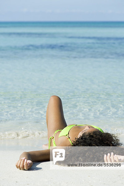 Frau im Bikini beim Sonnenbaden am Strand