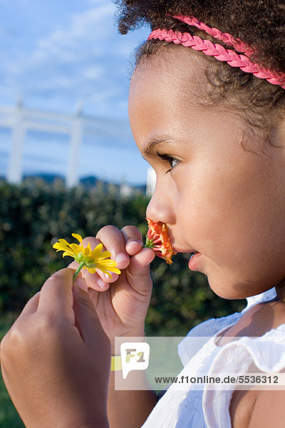 Kleines Mädchen riecht Blumen  Profil
