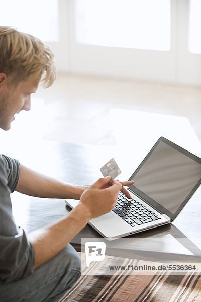 Mann mit Kreditkarte für einen Online-Einkauf