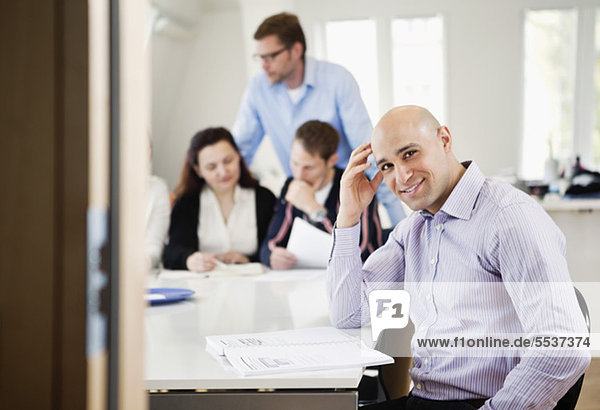 Smiling businessman with colleague in meeting at conference room