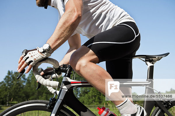 Midsection of male cyclist riding cycle