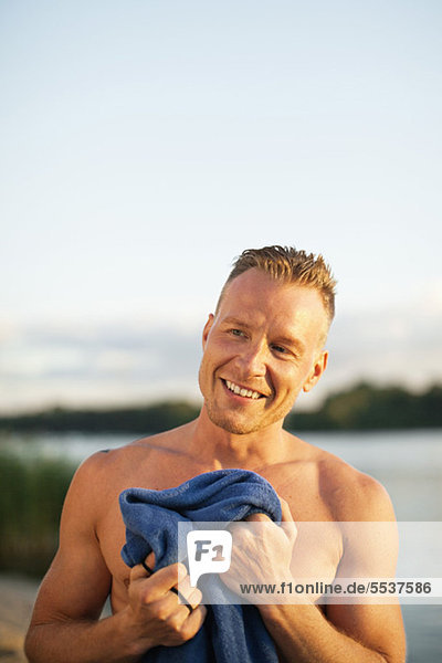 Nahaufnahme eines erwachsenen Mannes mit Handtuch am Strand