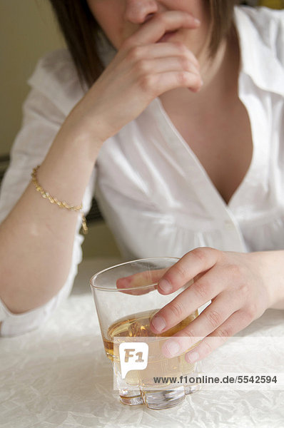 Frau hält ein Glas mit hochprozentigem Alkohol  weiblicher Alkoholismus