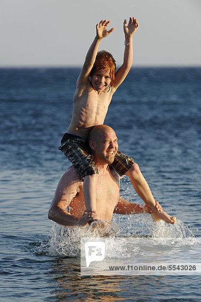 Father and son splashing around in the sea