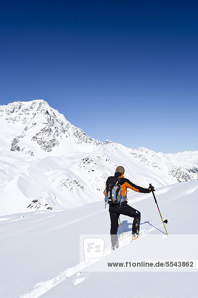 Skitourengeher beim Aufstieg zur hinteren Schöntaufspitze  Sulden  hinten der Ortler  Südtirol  Italien  Europa