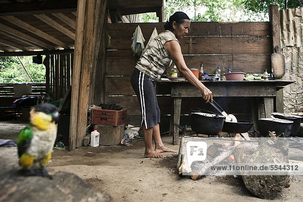 Carlota vom Volk der Quechua bereitet das Frühstück in ihrer Küche  in einem Dorf ohne Straßenverbindung im Regenwald des Oriente  Curaray  Ecuador  Südamerika