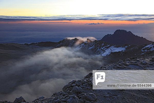 Bei Sonnenaufgang ziehen Wolken in den Krater des Kilimandscharo  Tansania  Afrika
