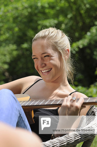 Junge Frau  Gitarre spielend  Deutschland  Europa  ÖffentlicherGrund