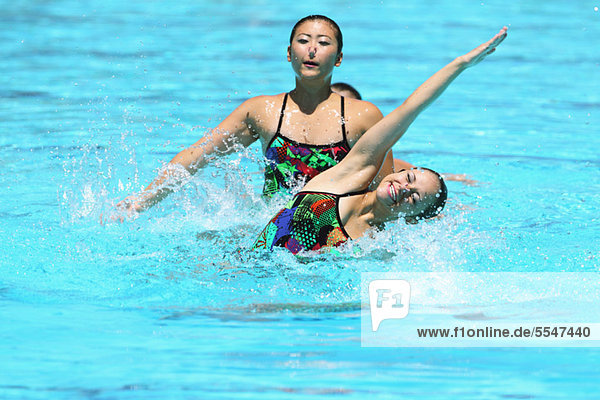 Swimmers Performing in Swimming Pool  Synchronized Swimming