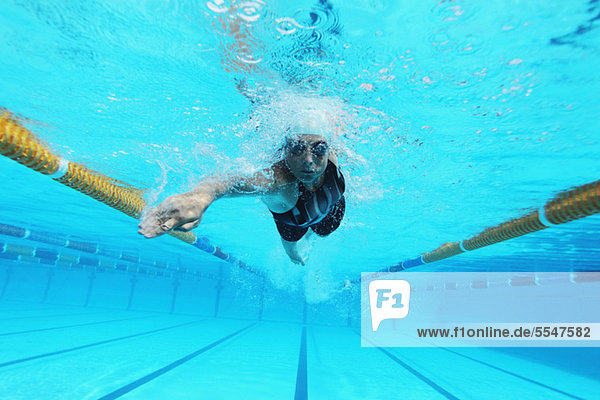 Unterwasseraufnahme Frau schwimmt in Schwimmbad