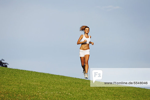 Young Woman Jogging auf Gras