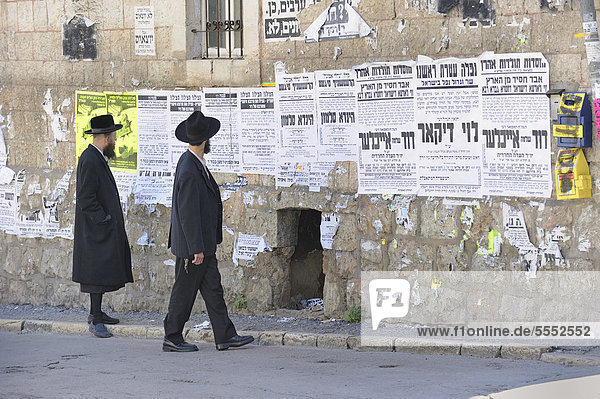 Orthodoxe Juden lesen Wandzeitungen im Stadtviertel Me'a Sche'arim oder Mea Shearim Jerusalem Israel Vorderasien