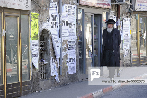 Street scene with an Orthodox Jew and typical wall newspapers in the district of Me'a She'arim or Mea Shearim  Jerusalem  Israel  Middle East