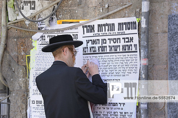 Street scene with an Orthodox Jew in the Me'a She'arim district  with typical wall newspapers  Jerusalem  Israel  Middle East  Asia